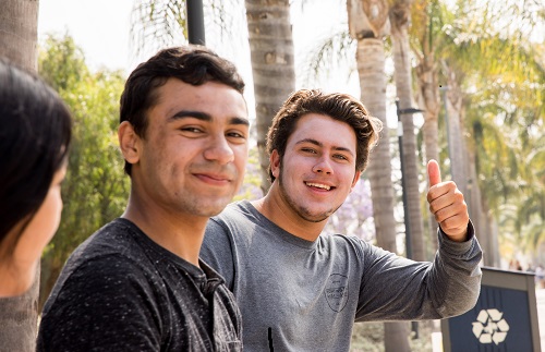 2 Boys looking into camera smiling with thumbs up